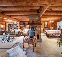 Zrubový rodinný dom, Veľká Lomnica - Interiér rodinného domu s dreveným dekorom, krbom a pohodlným sedením.