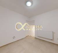 Polyfunkčný priestor na predaj, Zimná ul., Spišská Nová Ves - Prázdna miestnosť s bielymi stenami, krémovou podlahou a radiátorom v obchodných priestoroch.