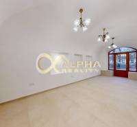 Polyfunkčný priestor na predaj, Zimná ul., Spišská Nová Ves - Obchodné priestory s oblúkovými dverami a podlahou s dreveným dekorom, biele steny, luster.