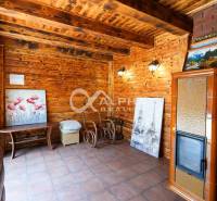 Exkluzívne: Rodinný dom, centrum, Spišská Nová Ves - Rodinný dom s dekoratívnymi drevenými stenami, kachľovou pecou a umeleckými dielami na stenách.