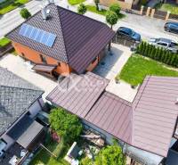 Exkluzívne: Rodinný dom, centrum, Spišská Nová Ves - Rodinný dom v Spišskej Novej Vsi s trávnikom a solárnymi panelmi na streche.