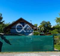 Exkluzívne záhradná chata, sídlisko Tarča, Spišská Nová Ves - Chata v Spišskej Novej Vsi, obklopená zeleňou a stromami, s plotom v popredí.