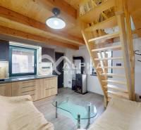 Exkluzívne záhradná chata, sídlisko Tarča, Spišská Nová Ves - Interiér chaty so schodiskom, skleneným stolíkom a kuchynskou linkou s dreveným dekorom.