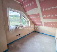 Rodinné domy, obec Danišovce, okr. Spišská Nová Ves - Izba v rodinnom dome s oknom a neúplne dokončenými stenami a stropom.