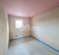 Rodinné domy, obec Danišovce, okr. Spišská Nová Ves - Prázdna miestnosť s oknom, omietnutými stenami a betónovou podlahou v rodinnom dome.