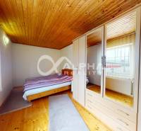 EXKLUZÍVNE Rodinný dom, širšie centrum, Spišská Nová Ves - Spálňa s podlahou s dreveným dekorom, vstavanou skriňou a posteľou v rodinnom dome.