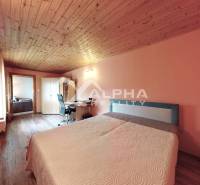 EXKLUZÍVNE Rodinný dom, širšie centrum, Spišská Nová Ves - Spálňa s podlahou s dreveným dekorom, pracovným stolom a manželskou posteľou v rodinnom dome.