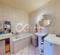 EXKLUZÍVNE Rodinný dom, širšie centrum, Spišská Nová Ves - Kúpeľňa v rodinnom dome s vaňou, práčkou a kruhovým zrkadlom.