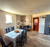 EXKLUZÍVNE Rodinný dom, širšie centrum, Spišská Nová Ves - Jedáleň rodinného domu so stolom, stoličkami a kuchynskou časťou; podlaha s dreveným dekorom.