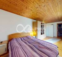 EXKLUZÍVNE Rodinný dom, širšie centrum, Spišská Nová Ves - Spálňa v rodinnom dome s dreveným stropom a podlahou s dreveným dekorom.