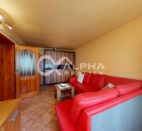 EXKLUZÍVNE Rodinný dom, širšie centrum, Spišská Nová Ves - Obývacia izba s červenou sedacou súpravou a sklenenou vitrínou v rodinnom dome.