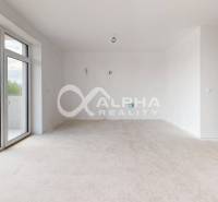 3i byty s balkónom, terasou, garážovým státím, Zelené údolie, Sp. Nová - Svetlá miestnosť s veľkým oknom a balkónom v 3-izbovom byte, biele steny.