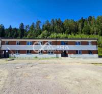 EXKLUZÍVNE novostavby bytov s terasou, parkovaním, Novoveská Huta, okr - Budova v Spišskej Novej Vsi pri lese, súčasť 3-izbového bytu, parkovisko v popredí.