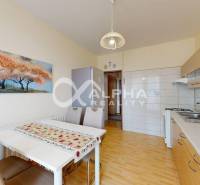 EXKLUZÍVNE 5i byt s loggiou, sídl. Západ, Spišská Nová Ves - Kuchyňa s bielym stolom, podlaha s dreveným dekorom, obrazom a kuchynskou linkou v 5+ izbovom byte.