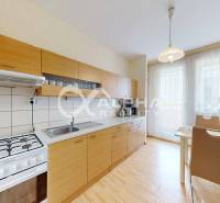 EXKLUZÍVNE 5i byt s loggiou, sídl. Západ, Spišská Nová Ves - Kuchyňa vo veľkom byte s podlahou s dreveným dekorom, svetlým nábytkom a jedálenským stolom.