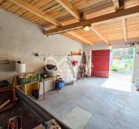 Prenájom garáž, centrum, Spišská Nová Ves - Interiér garáží s betónovou podlahou, dreveným stropom a potrebami na uskladnenie.