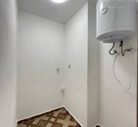 Vám ponúka na predaj rodinný dom v Komárne, ča - Úložný priestor v rodinnom dome s keramickou dlažbou a bojlerom na stene.