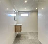 Vám ponúka na predaj rodinný dom v Komárne, ča - Kúpeľňa v rodinnom dome s keramickou dlažbou a svetlými obkladmi.