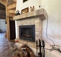 Vám ponúka na predaj rodinný dom v Komárne, ča - Krby v rodinnom dome s košíkom na drevo a tehlovým obkladom.