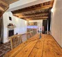 Vám ponúka na predaj rodinný dom v Komárne, ča - Interiér rodinného domu s podlahou s dreveným dekorom a dreveným stropom.