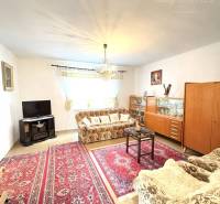 IBA U NÁS !!! ponúka EXKLUZÍVNE na predaj rodin - Obývačka v rodinnom dome s kobercom, televízorom a dreveným dekorom nábytku.