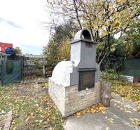 IBA U NÁS !!! ponúka EXKLUZÍVNE na predaj rodin - Záhrada rodinného domu v Komárne so stromami a záhradným grilom z tehlových blokov.