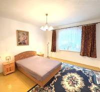 IBA U NÁS !!! ponúka EXKLUZÍVNE na predaj rodin - Spálňa v rodinnom dome so svetlom, kobercom a posteľou, vedľa nočný stolík.