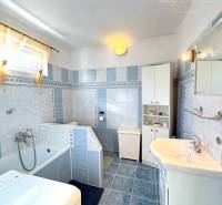 IBA U NÁS !!! ponúka EXKLUZÍVNE na predaj rodin - Kúpeľňa v rodinnom dome s vaňou, práčkou a modrými dlaždicami na stenách a podlahe.