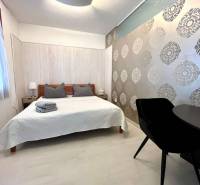 Vám EXKLUZÍVNE ponúka NA PRENÁJOM moderný 2 iz - Svetlá spálňa s posteľou a vzorovanou tapetou v 2-izbovom byte.