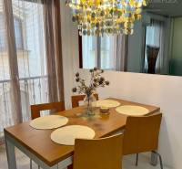 Vám EXKLUZÍVNE ponúka NA PRENÁJOM moderný 2 iz - Jedálenský stôl so stoličkami pod výrazným lustrom v 2-izbovom byte.