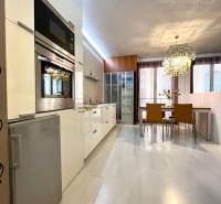 Vám EXKLUZÍVNE ponúka NA PRENÁJOM moderný 2 iz - Kuchyňa s jedálenským kútom v 2-izbovom byte, podlaha s dreveným dekorom, štýlový luster.