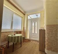 Vám ponúka na predaj 4 izbový rodinný dom  s r - Interiér rodinného domu s kobercovou podlahou, stolom a stoličkou.