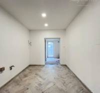 Vám ponúka  na predaj budovu na BÝVANIE aj PODN - Predsieň s dlažbou, bielymi stenami a vstavaným osvetlením v modernizovanej budove.