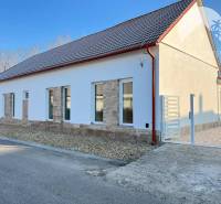 Vám ponúka  na predaj budovu na BÝVANIE aj PODN - Rodinný dom s bielou omietkou, sedlovou strechou a kamennými obkladmi. Štrkovitý dvor.