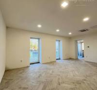 Vám ponúka  na predaj budovu na BÝVANIE aj PODN - Prázdna miestnosť s podlahou, tromi veľkými oknami a stenami budovy.