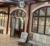 Vám ponúka do PRENÁJMU čarovný, úplne zrekonštr - Presklená veranda v rodinnom dome s dreveným dekorom a vintage sedačkami.