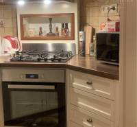 Vám ponúka do PRENÁJMU čarovný, úplne zrekonštr - Kuchyňa v rodinnom dome s bielymi skrinkami, rúrou a zabudovaným digestorom.