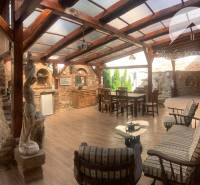 Vám ponúka do PRENÁJMU čarovný, úplne zrekonštr - Krytá terasa v rodinnom dome s tehlovou stenou, drevenými trámami a podlahou s dreveným dekorom.