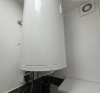 Vám ponúka exkluzívne na predaj moderný, komple - Elektrický bojler v kúpeľni 1-izbového bytu zobrazujúci detaily inštalácie.