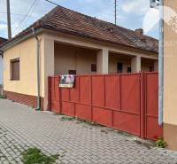 Reality KOMPLEX Vám ponúka EXKLUZÍVNE na predaj rodinný dom, ktorý sa  - Rodinný dom vo Veľkom Mederi s červenou bránou a tehlovým základom.