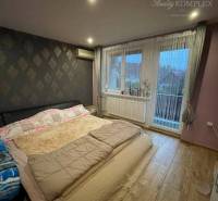 !!! LEN U NÁS!!! Vám ponúka NA PREDAJ rodinný d - Spálňa s veľkým oknom v rodinnom dome s drevenou podlahou a tapetovanou stenou.