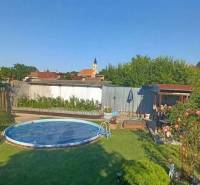 !!! LEN U NÁS!!! Vám ponúka NA PREDAJ rodinný d - Záhrada rodinného domu na Hlavnej ulici v Kostolných Kračanoch s bazénom a rastlinami.