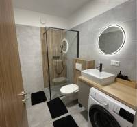 Vám ponúka na Prenájom 2-izbový byt s loggiou  - Kúpeľňa v 2-izbovom byte s práčkou, kruhovým zrkadlom a sprchovým kútom.