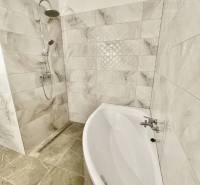 Vám ponúka modernú 4-izbovú novostavbu v Dunajs - Kúpeľňa v rodinnom dome s voľne stojacou vaňou a sprchou, dlažba s mramorovým vzhľadom.