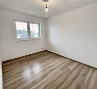 Vám ponúka modernú 4-izbovú novostavbu v Dunajs - Izba v rodinnom dome s podlahou s dreveným dekorom a jednoduchým osvetlením.