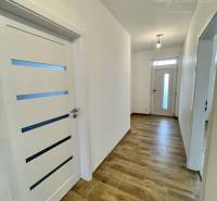 Vám ponúka modernú 4-izbovú novostavbu v Dunajs - Chodba v rodinnom dome s bielymi dverami a podlahou s dreveným dekorom.