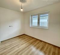 Vám ponúka modernú 4-izbovú novostavbu v Dunajs - Izba v rodinnom dome s podlahou s dreveným dekorom a jednoduchým osvetlením.