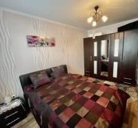 Vám ponúka 3-izbový byt s loggiou po kompletnej - Spálňa v 3-izbovom byte s elegantným nábytkom a podlahou s dreveným dekorom.