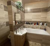 Vám ponúka 3-izbový byt s loggiou po kompletnej - Kúpeľňa s vaňou a podlahou s dreveným dekorom v 3-izbovom byte.