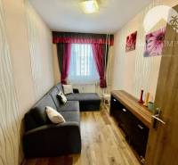 Vám ponúka 3-izbový byt s loggiou po kompletnej - Obývací priestor v 3-izbovom byte s podlahou s dreveným dekorom a elegantným osvetlením.